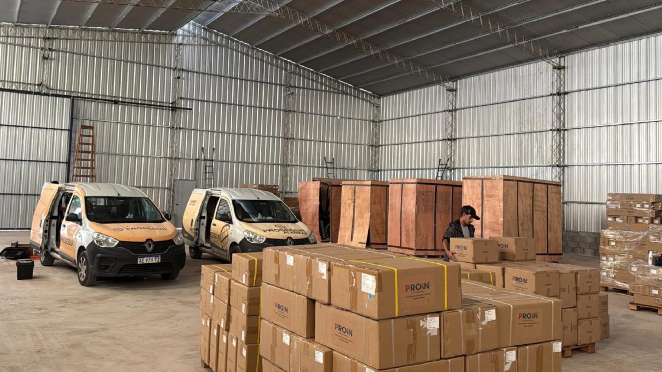 Nave del depósito con camionetas de reparto y mercadería PROIN lista para despacho